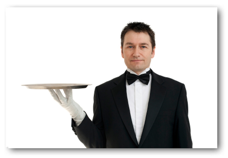 A butler in formal attire holding a silver tray with one hand. - International Hotel School
