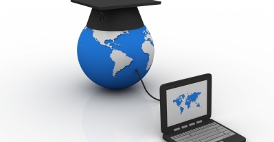 A globe with a graduation cap on top, connected to a laptop displaying a world map. - International Hotel School