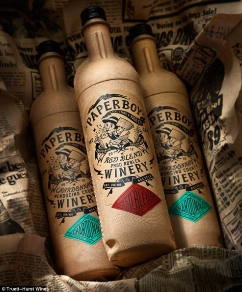Three bottles of Paperboy Winery wine wrapped in brown paper and placed in a bed of newspaper. - International Hotel School
