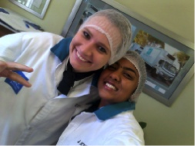 Two students wearing culinary uniforms and hairnets posing for a selfie with smiles. - International Hotel School