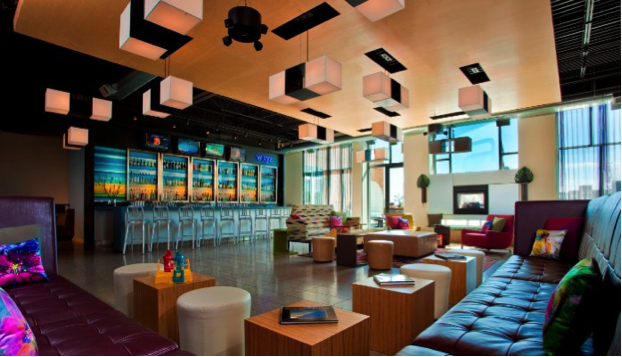Contemporary lounge interior featuring a bar, seating, and decorative lighting. - International Hotel School