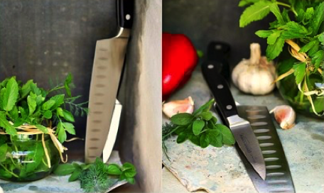Two kitchen knives placed next to fresh herbs, garlic, and a red bell pepper on a countertop. - International Hotel School