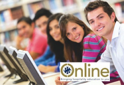 Group of students participating in an online learning session with computers in a classroom setting. - International Hotel School