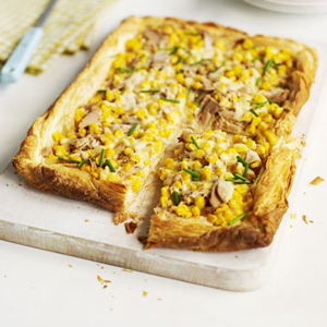 Tuna and chilli slice with corn and chives on a wooden cutting board. - International Hotel School