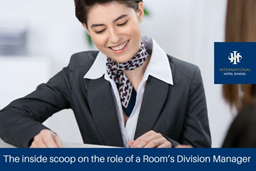 A woman in a business suit smiling while reviewing documents at a desk, associated with the International Hotel School. - International Hotel School