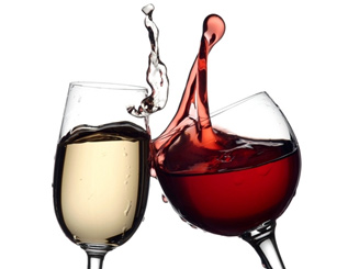Two wine glasses clinking together, one filled with red wine and the other with white wine. - International Hotel School