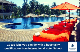 Lounge chairs with orange cushions beside a swimming pool at a resort. - International Hotel School
