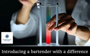 A bartender using a test tube to create a colorful drink at the International Hotel School. - International Hotel School