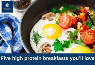 A skillet containing two eggs, mushrooms, tomatoes, and various vegetables garnished with herbs. - International Hotel School