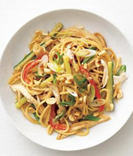 A plate of peanut noodle chicken with vegetables including bell peppers and green onions. - International Hotel School