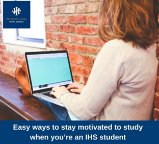 Student working on a laptop while seated on a wooden bench in a study area. - International Hotel School