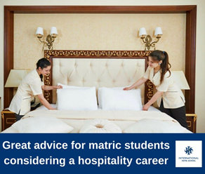 Two hospitality students arranging pillows on a neatly made bed in a hotel room. - International Hotel School