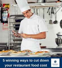 Chef in a white uniform using a tablet in a kitchen with various food dishes on the counter. - International Hotel School