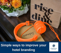 Orange headphones placed next to a branded Canopy box on a table. - International Hotel School