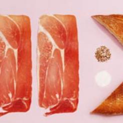 Two slices of ham and a piece of fish with seasoning on a pink background. - International Hotel School