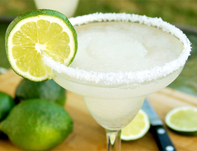 A margarita cocktail served in a glass with a lime slice and salt rim. - International Hotel School