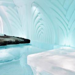 Interior view of an ice hotel featuring sculpted ice beds and intricate designs. - International Hotel School