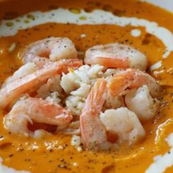 A plate of shrimp and crab served in a rich orange sauce with seasoning. - International Hotel School