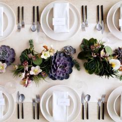 A beautifully arranged dinner table featuring plates, cutlery, and a succulent centerpiece. - International Hotel School