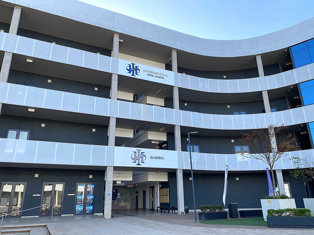 Exterior view of the International Hotel School building with signage and modern architecture. - International Hotel School