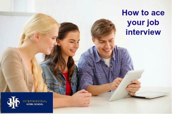 Three students discussing job interview tips while looking at a tablet at International Hotel School. - International Hotel School