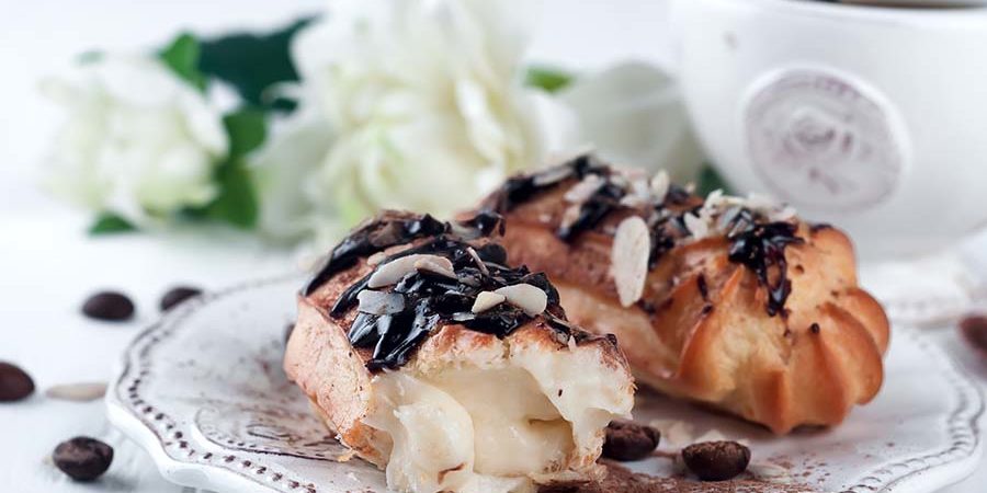 Puff pastry dessert topped with chocolate and almonds served on a decorative plate. - International Hotel School