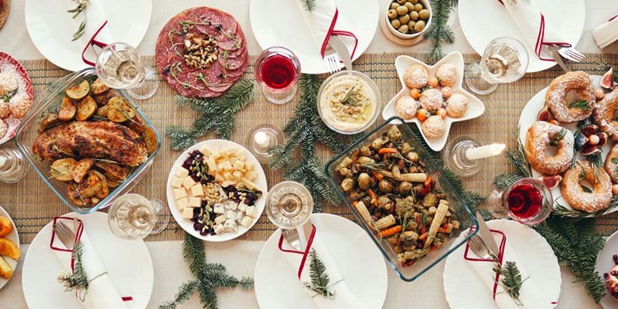 A table set with various festive dishes including meats, salads, and desserts. - International Hotel School
