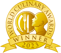 Logo of the World Culinary Awards 2023 Winner featuring a golden design with utensils and a silhouette. - International Hotel School